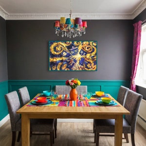 May include: A dining room table with six chairs, set with colourful placemats and dishes. A painting of a blue police box in a starry sky hangs on the wall above the table. A colourful chandelier hangs from the ceiling.