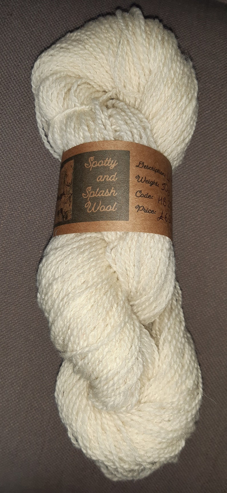May include: A ball of off-white yarn labelled "Spotty and Splash Wool" with a description of "Description: Light Weight: 50g Code: 1182 Price: &pound;6.50"