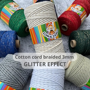 Op de afbeelding: Spoelen gevlochten katoenen koord van 3 mm met glittereffect in verschillende kleuren, waaronder groen, rood, blauw en grijs. De tekst "Cotton cord braided 3mm GLITTER EFFECT" is zichtbaar.