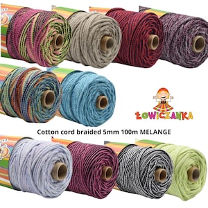 Può includere: Una collezione di rocchetti di cordoncino di cotone intrecciato in vari colori, tra cui rosa, grigio, rosso e blu. Il testo "Cotton cord braided 5mm 100m MELANGE" è stampato in basso. I rocchetti sono disposti in file.