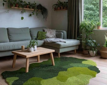 Op de afbeelding: Een woonkamer met een groene bank, houten salontafel en een opvallend, organisch gevormd tapijt in groentinten. Het tapijt heeft een gelaagd ontwerp. Planten en groen versterken de natuurlijke esthetiek van de kamer.