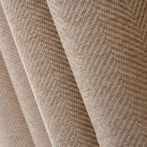 May include: Close-up of beige fabric with a herringbone pattern. The fabric is woven and has a textured surface.