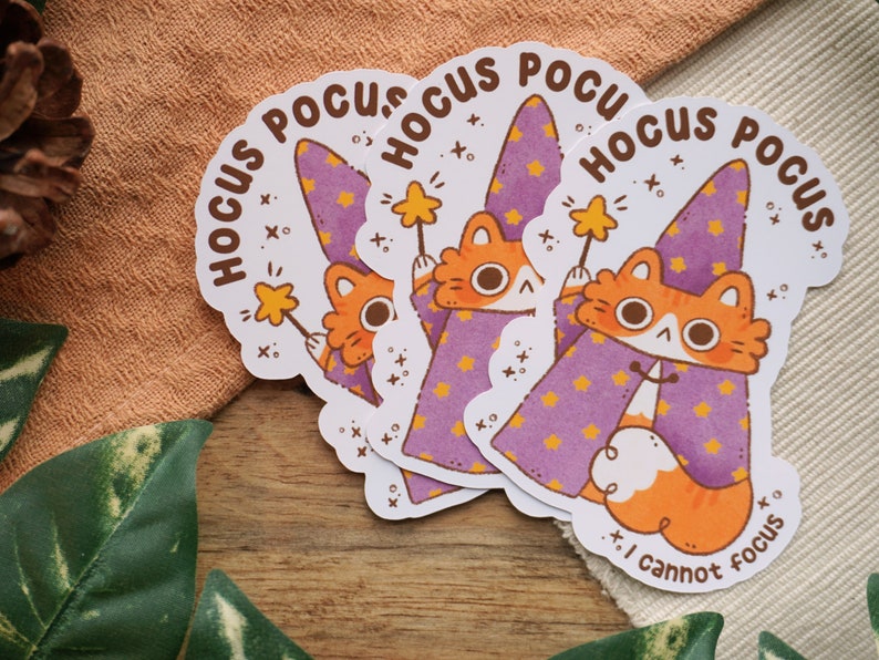 May include: Three sticker sheets with a cartoon cat wearing a purple wizard hat and holding a magic wand. The text on the stickers says "Hocus Pocus I cannot focus".