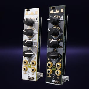 Puede incluir: Dos m&oacute;dulos de sintetizador electr&oacute;nico, uno blanco y otro negro, con perillas negras y detalles dorados. Los m&oacute;dulos tienen el texto "M.M.K" y "MAKE SYNTHS NOT WAR!" impreso. Los m&oacute;dulos est&aacute;n montados sobre una base plateada.