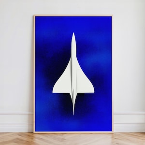 May include: A framed print featuring a white Concorde aircraft against a deep blue background. The aircraft is centered and in sharp focus, with a minimalist design. The frame is a light wood color, adding a natural touch to the artwork.