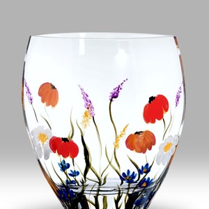 May include: A clear glass vase with a hand-painted floral design. The vase features a variety of flowers in shades of red, orange, purple, blue, and white.