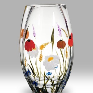 May include: A clear glass vase with a hand-painted design of colorful wildflowers. The vase has a rounded, oval shape and a slightly flared opening.