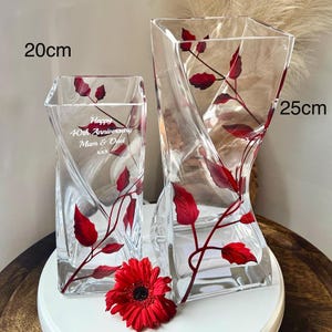 May include: Two clear glass vases with red leaf designs. The taller vase is 25 cm tall and the shorter vase is 20 cm tall. The shorter vase has the text "Happy 40th Anniversary Mum & Dad xxx" engraved on it.