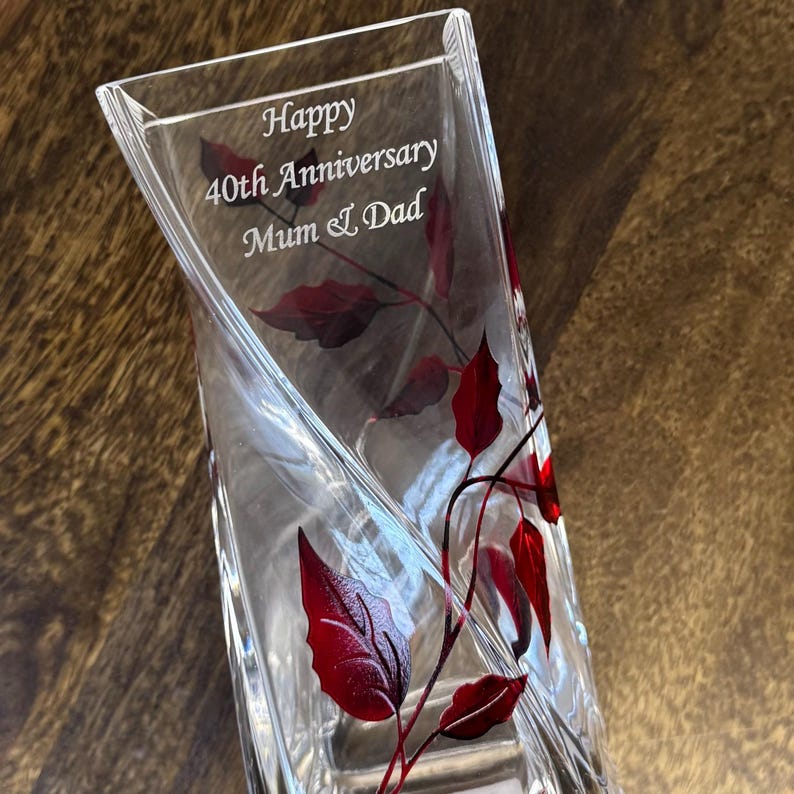 May include: A clear glass vase with a red leaf design. The vase is engraved with the text "Happy 40th Anniversary Mum & Dad".