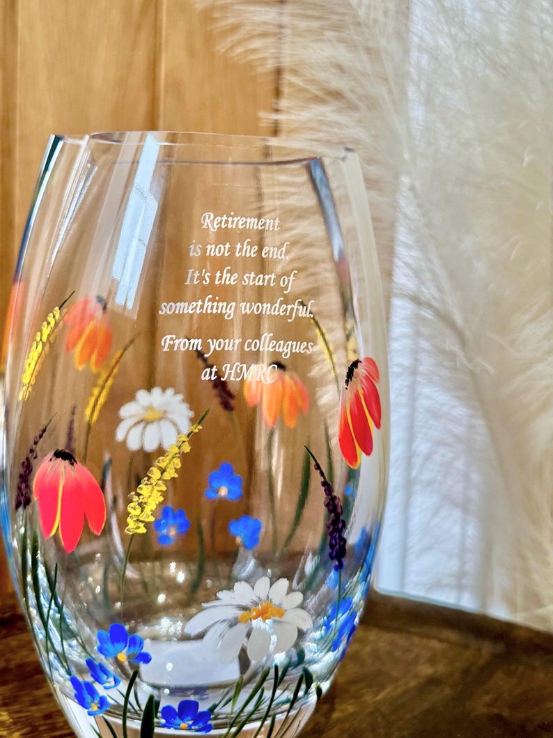 May include: A clear glass vase with a floral design painted on it. The vase has a quote inscribed on it that reads: "Retirement is not the end. It's the start of something wonderful. From your colleagues at HMRO."