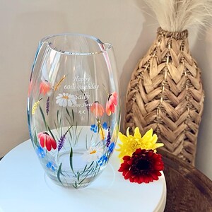 May include: A clear glass vase with a hand-painted floral design. The vase has a personalized message that reads "Happy 60th Birthday Sally Love Steve xx".