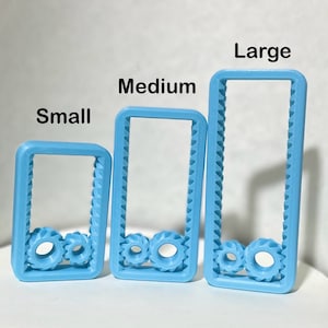 May include: Three blue plastic frames with gear-shaped cutouts. The frames are labeled "Small", "Medium", and "Large" from left to right.