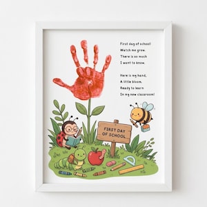 May include: A framed print featuring a red handprint flower, a ladybug reading a book, a caterpillar, a bee, and a sign reading FIRST DAY OF SCHOOL. The text reads: First day of school! Watch me grow. There is so much I want to know. Here is my hand, A little bloom. Ready to learn In my new classroom!