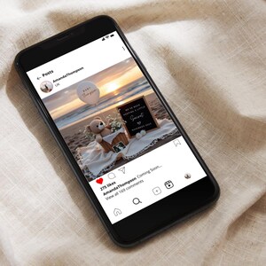 May include: A smartphone displays a beach scene with a baby announcement. A teddy bear, flowers, and a sign that reads "We've been keeping a little secret" are in a basket. A balloon says "Baby Thompson".