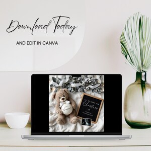 May include: A laptop screen displaying a Christmas-themed baby announcement with a teddy bear holding a white ornament that says "Baby Thompson". The announcement reads "I'll be home for Christmas" with a heart and the date "Arriving December 2023".