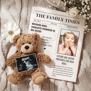 May include: A brown teddy bear holds an ultrasound image, positioned next to a newspaper titled "The Family Times." The headline reads "Charlotte Promoted to Big Sister!" with an image of a young girl. The background is a textured, neutral-toned blanket.