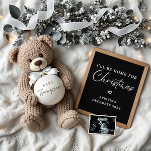 May include: A white Christmas ornament with the text "Baby Thompson" on it, held by a brown teddy bear. A black letter board with the text "I'll be home for Christmas" and "Arriving December 202X" is in the background.