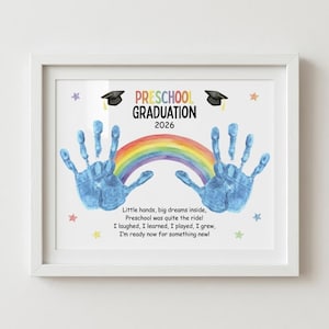 May include: Framed preschool graduation print with blue handprints, a rainbow, and the text "Preschool Graduation 2026." The print includes a poem and star accents, all within a white frame.