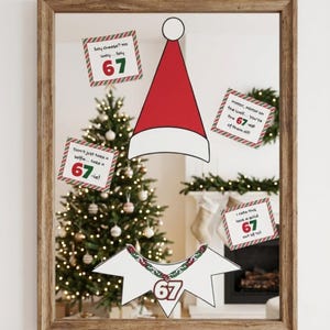May include: A mirror with a wooden frame reflecting a Christmas tree and fireplace. Decorative cutouts include a red Santa hat, a shirt with a "67" necklace, and signs with the number "67" and phrases like "Say cheese?" and "Mirror, mirror."