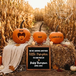 Può includere: Tre zucche arancioni su balle di fieno. La zucca a sinistra ha un intaglio a forma di cuore con una piccola zucca all'interno etichettata #2 e il testo MOM. La zucca centrale è etichettata DAD e quella a destra CHARLOTTE. Un cartello recita WE'RE ADDING ANOTHER little Pumpkin TO OUR PATCH! Baby Thompson APRIL 202X.