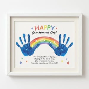 May include: A framed print featuring the text HAPPY Grandparents Day! with two blue handprints, a colorful rainbow, and the poem: You bring sunshine to my day, Chasing all the clouds away, Like a rainbow in the sky, You make me smile and lift me high!