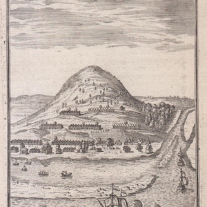 Può includere: Un'incisione storica in bianco e nero che raffigura un paesaggio costiero con una grande collina, numerosi piccoli edifici e un fiume. Un banner nella parte superiore mostra il testo GAMMALAMME. Diverse navi a vela sono visibili sull'acqua in primo piano.