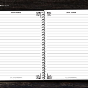 May include: A blank, lined notebook with a black and white spiderweb design on the cover. The notebook has a spiral binding and the text "HORROR WORKBOOK" at the top of the page.