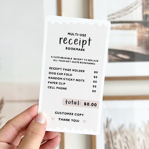 Op de afbeelding: Een witte kaart met een zwart-wit ontwerp. De kaart zegt "MULTI-USE receipt BOOKMARK" en somt verschillende toepassingen voor de kaart op, zoals "RECEIPT PAGE HOLDER", "DOG EAR FOLD", "RANDOM STICKY NOTE", "PAPER CLIP" en "CELL PHONE". De kaart zegt ook "total: € 0,00" en "CUSTOMER COPY THANK YOU".