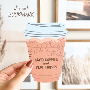 Op de afbeelding: Een gestanst bladwijzer in de vorm van een ijscoffiebeker. De beker is perzik van kleur met een lichtblauw deksel en de woorden "ICED COFFEE and PLOT TWISTS". De woorden "die cut BOOKMARK" staan erboven.