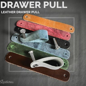 May include: A set of seven leather drawer pulls in various colours, including brown, green, blue, red, and orange. Each pull has a hole for a screw and a loop for pulling. The text "Leather Drawer Pull" is visible at the top of the image.
