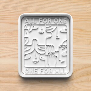 May include: White square cookie cutter with the text "ALL FOR ONE ONE FOR ALL" and a stylized design of four faces.