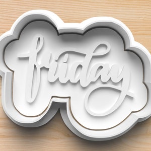 May include: White plastic cookie cutter shaped like a cloud with the word "friday" written in a cursive font.