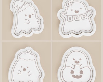 May include: Four white Halloween-themed cookie cutters. The designs include a ghost wearing a witch hat, a ghost with the word "BOO", a ghost with a hat, and a ghost inside a pumpkin. Each cutter has a wavy outline.