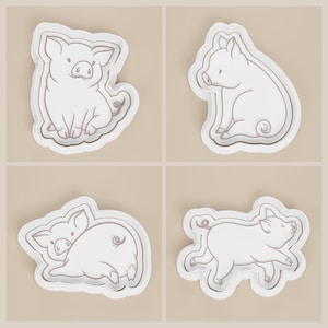 May include: Four white pig-shaped cookie cutters with gray outlines. The pigs are in different poses: sitting, running, and curled up. The cookie cutters are on a light beige background.