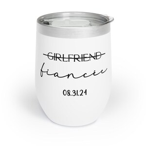 May include: White stainless steel wine tumbler with the text "GIRLFRIEND" crossed out and "fianc&eacute;e" written below it. The date "08.31.24" is printed below the text.