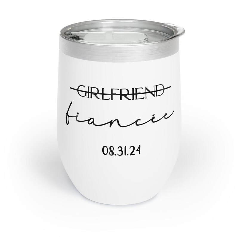 May include: White stainless steel wine tumbler with the text "GIRLFRIEND" crossed out and "fianc&eacute;e" written below it. The date "08.31.24" is printed below the text.