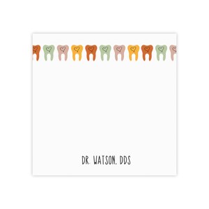 K&ouml;nnte beinhalten: Eine wei&szlig;e Karte mit einem Rand aus bunten Z&auml;hnen mit Herzen darin. Der Text "DR. WATSON. DDS" befindet sich am unteren Rand der Karte.