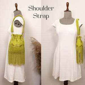 May include: A lime green beaded drawstring handbag featuring a long shoulder strap and a dense fringe of matching beads at the base. The bag is displayed on a mannequin wearing a white dress. The text Shoulder Strap is visible in the image.