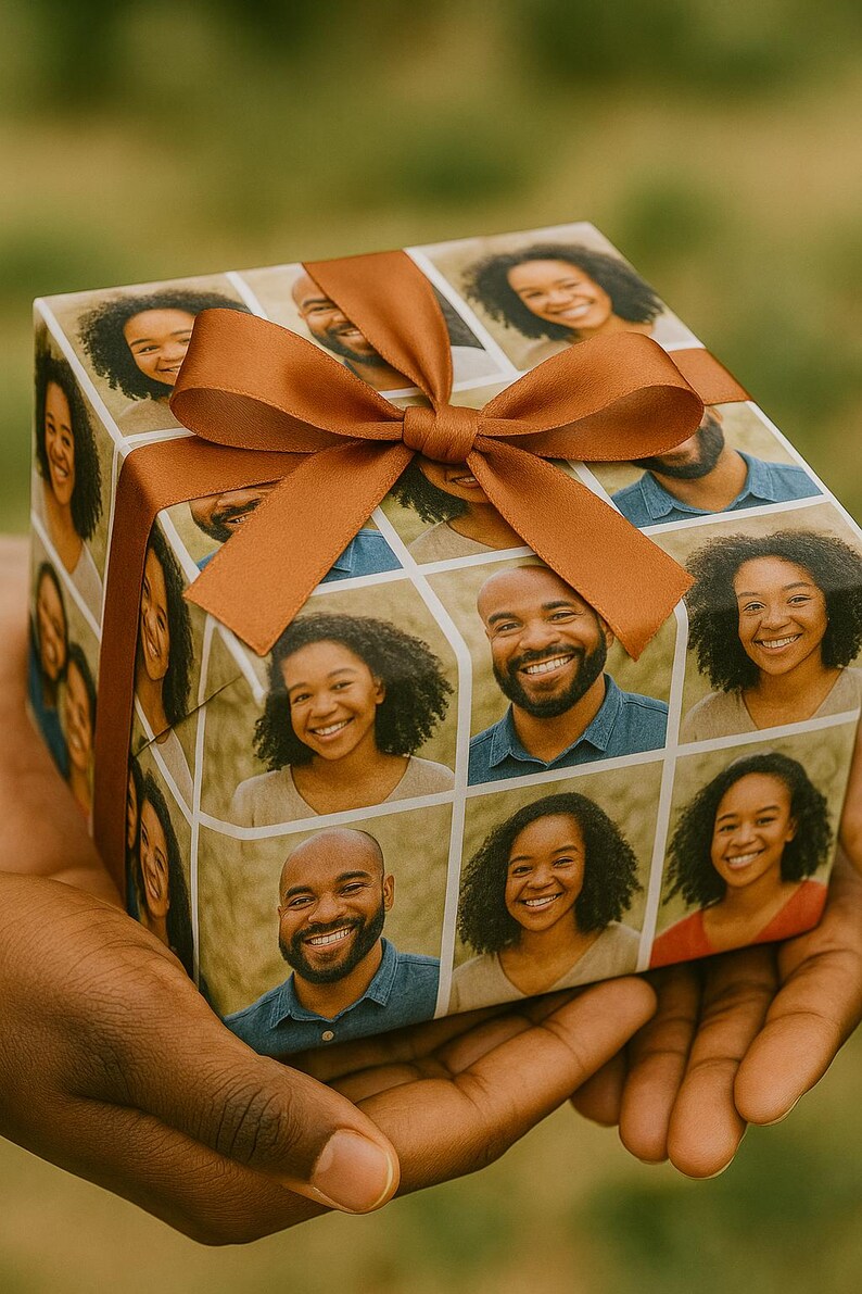 May include: A wrapped gift box featuring a collage of smiling faces, tied with a brown ribbon and bow. The wrapping paper displays a grid of individual portraits. The box is held in a person's hands.
