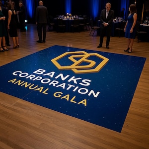 Op de afbeelding: Een blauwe dansvloer met een gouden geometrisch logo en de tekst "BANKS CORPORATION ANNUAL GALA". De vloer staat op een houten vloer in een grote evenementenruimte. Mensen staan rond de dansvloer.