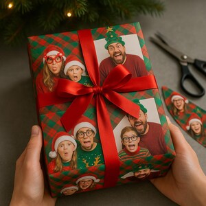 May include: A wrapped Christmas gift featuring a family photo, wrapped in red and green plaid paper. The gift is tied with a red ribbon and bow. A pair of scissors is visible in the background.