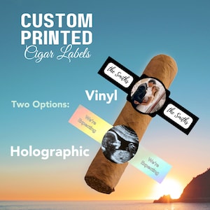 May include: Two custom printed cigar labels, one with a photo of a couple and the text "the Smiths" and the other with an ultrasound image and the text "We're Expecting". The labels are on a brown cigar. The text "Vinyl" and "Holographic" are also visible.