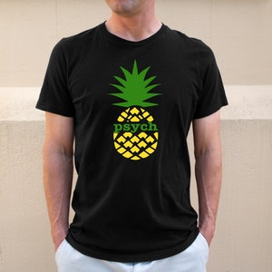 May include: Black t-shirt featuring a green and yellow pineapple graphic with the word "psych" printed on the front.