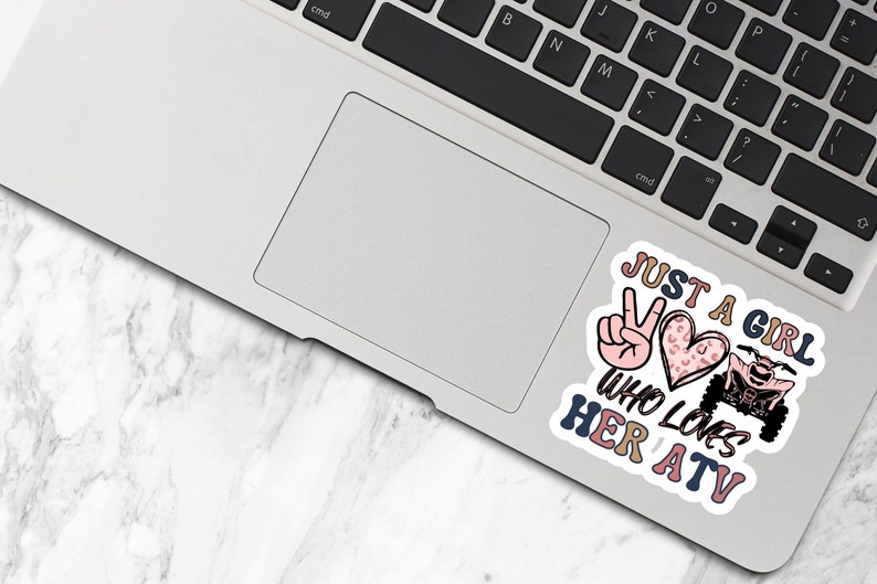 May include: A sticker featuring a peace sign, a heart with a leopard print, and an ATV. The text reads "Just a girl who loves her ATV".