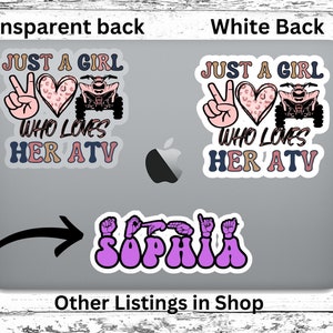 May include: Two stickers on a laptop. The first sticker is pink, white, and brown with the text "Just a girl who loves her ATV". The second sticker is purple and features the word "Sophia" in sign language.