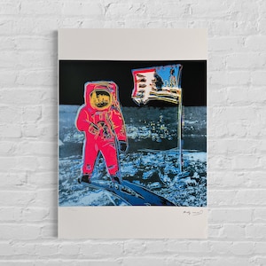Peut inclure: Une sérigraphie pop art représentant un astronaute rose sur la lune avec un drapeau américain flottant. L'astronaute porte une combinaison spatiale rouge avec un casque jaune. L'œuvre est signée Andy Warhol.
