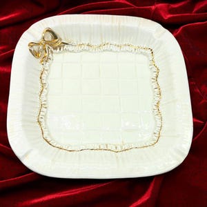 Posacenere in maiolica trapuntata, stile Mid-Century Modern italiano, marcato Made Italy, con motivo a fiocco e volant. Presenta alcune screpolature superficiali (vedi foto), circa 1950-1960.