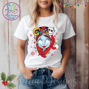 Op de afbeelding: Wit T-shirt met een kleurrijke kerstthema-afbeelding van Sally uit The Nightmare Before Christmas. De afbeelding toont Sally met een kerstmanmuts en Jack Skellington's hoofd op haar hoofd.