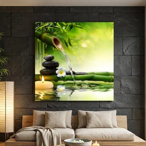 May include: A tranquil interior scene with a canvas print of a zen garden, showcasing a bamboo fountain, stacked stones, and a lit candle. The room features a wooden sofa, a round coffee table, and a large window overlooking a bamboo grove.