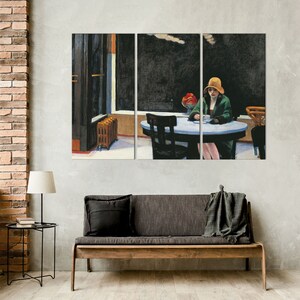 K&ouml;nnte beinhalten: Triptychon-Leinwanddruck von Edward Hoppers Gem&auml;lde "Nighthawks". Das Kunstwerk zeigt eine Frau mit Hut und Mantel, die an einem Tisch in einem Diner sitzt. Die Szene spielt nachts mit dunkler Au&szlig;en- und Innenbeleuchtung.